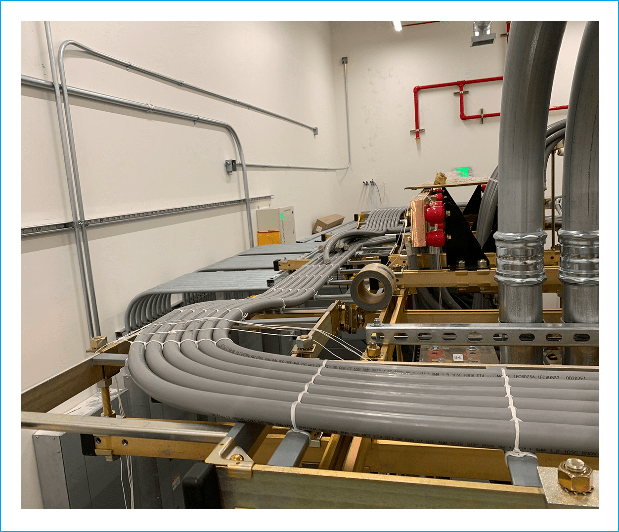 Industrial cables and pipes in utility room.